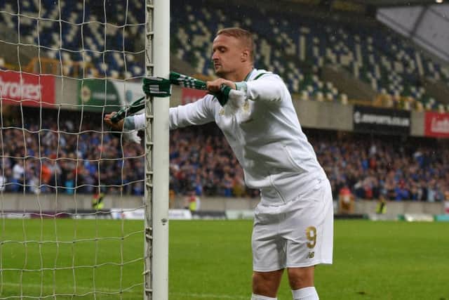 Celtic striker Leigh Griffiths ties a scarf to the goalpost at full-time. Picture: Getty