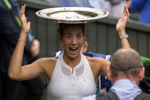 Hats the way to do it: Garbine Muguruza tries the trophy on for size. Photograph: Steven Paston/PA