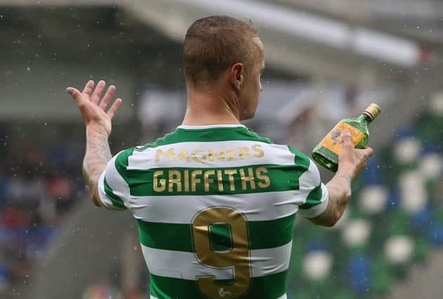 Leigh Griffiths holds a glass bottle thrown at him from the stands during the match against Linfield. Picture: PA