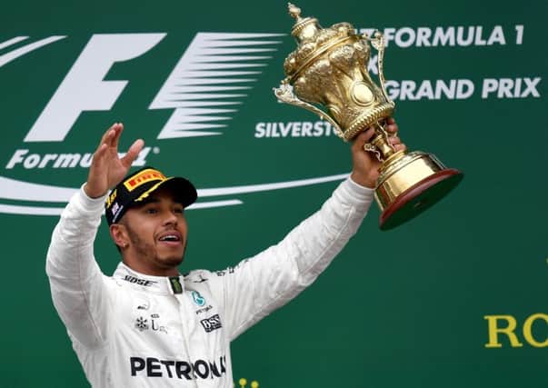 Mercedes' driver Lewis Hamilton celebrates with his trophy on the podium after the British Formula One Grand Prix at the Silverstone. Picture: Getty