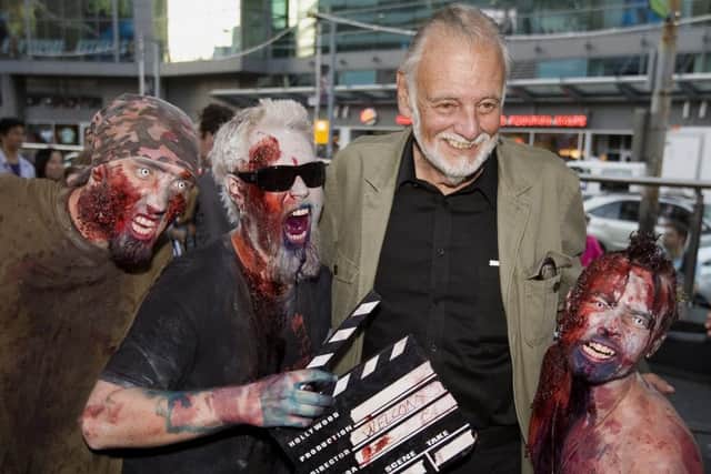 Romero poses with fans dressed as zombies after accepting a special award during the Toronto International Film Festival in 2009. Picture: Darren Calabrese/The Canadian Press/AP