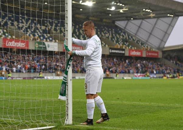 Leigh Griffiths ties a Celtic scarf on to the goalpost after his side's 2-0 win over Linfield. Picture: Getty
