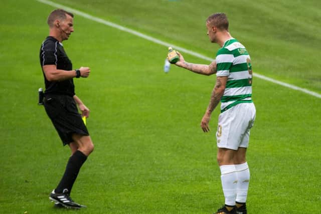 Celtic striker Leigh Griffiths shows the referee an empty bottle of Buckfast after it was thrown at him. Picture: Liam McBurney/PA Wire