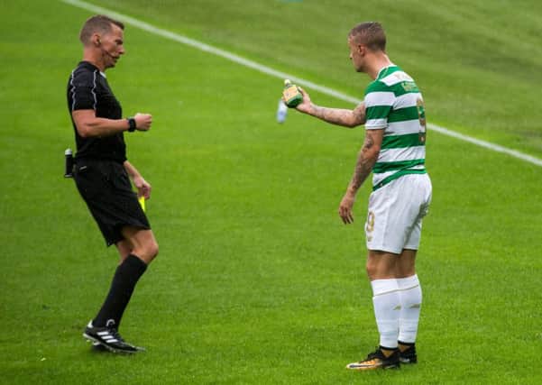 Celtic striker Leigh Griffiths shows the referee an empty bottle of Buckfast after it was thrown at him. Picture: Liam McBurney/PA Wire