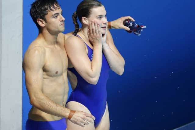 Grace Reid and Tom Daley wait to hear that they won silver after their performance in the mixed 3m synchro springboard diving final. Picture: AP Photo/Darko Bandic