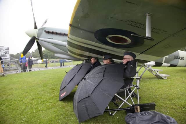 A wash out at today's airshow - crew members sitting under the wing of a spitfire