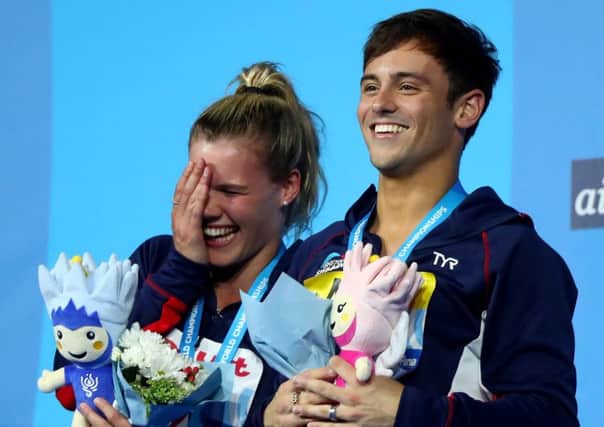 Edinburgh Diving Club's Grace Reid and Tom Daley collect their 3m mixed synchro silver medals. Picture: Clive Rose/Getty Images
