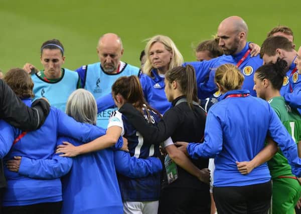 Anna Signeul and her players console themselves with a group hug following their defeat by Portugal. Picture: Lorraine Hill.