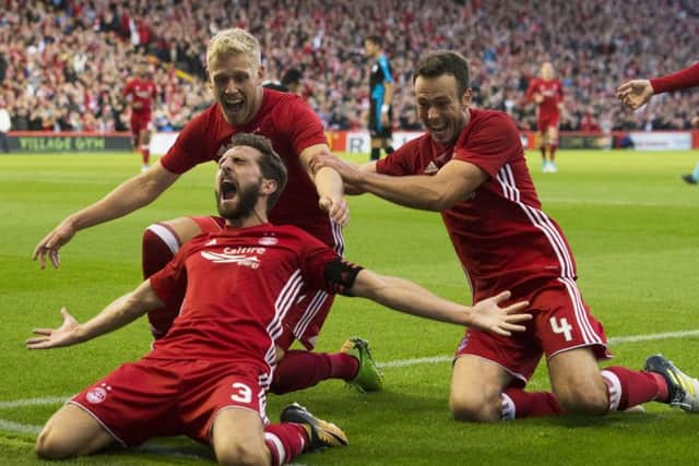 Aberdeen goal hero Graeme Shinnie celebrates with Jayden Stockley and Andy Considine, right, after giving his side a 2-1 lead. Picture: SNS