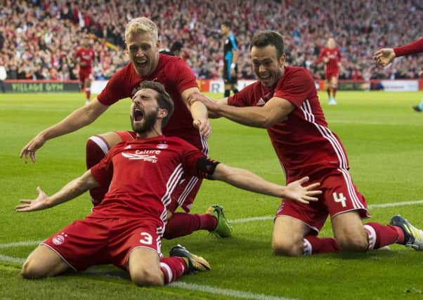 Aberdeen goal hero Graeme Shinnie celebrates with Jayden Stockley and Andy Considine, right, after giving his side a 2-1 lead. Picture: SNS