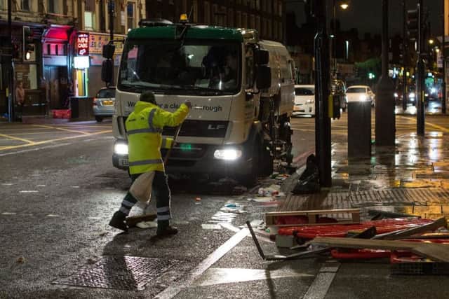Municipal staff clean the trashed streets following a demonstration demanding justice after the death of Rashan Charles. Picture; Getty
