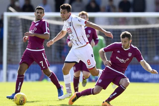 Ross County's Tim Chow (centre) gets away from Danny Denholm. Picture: SNS/Sammy Turner