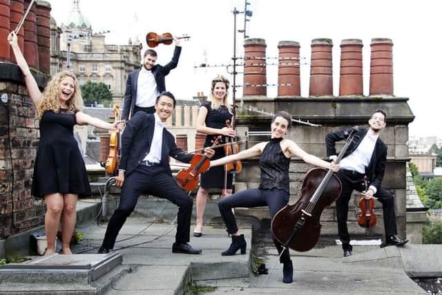 Members of the Catalonian string orchestra Orquestra de Cambra d'Emporda on the rooftops over edinburgh