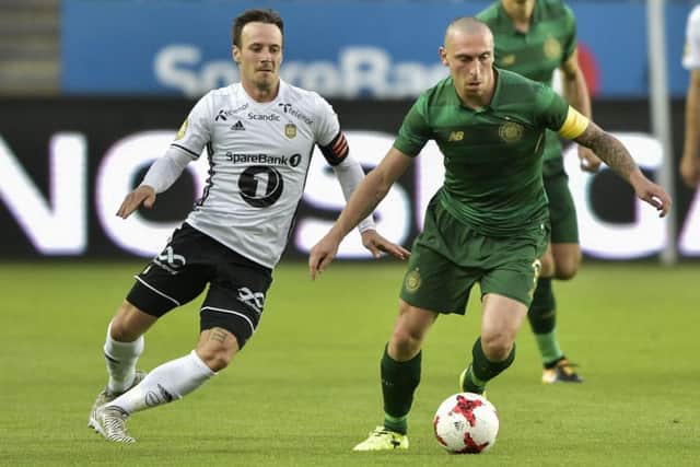 Celtic's Scott Brown, right, and Mike Jensen battle for possession. Picture: AP