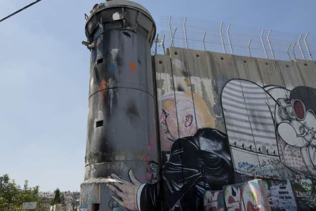 A mural depicts President Donald Trump kissing an Israeli army watchtower, part of Israel's West Bank separation barrier in the West Bank city of Bethlehem. Picture: AP Photo/Nasser Nasser