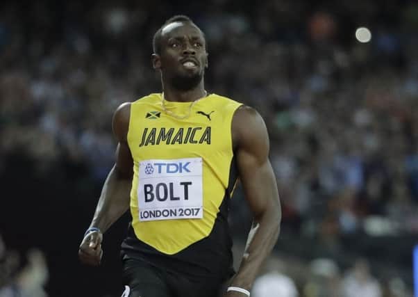 Usain Bolt crosses the line to win his Men's 100m first round heat. Picture: AP.