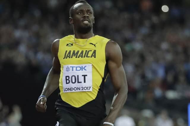 Usain Bolt crosses the line to win his Men's 100m first round heat. Picture: AP.