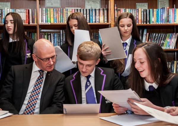 Education Secretary John Swinney, tasked by Nicola Sturgeon with improving falling standards, meets pupils as they receive their exam results.