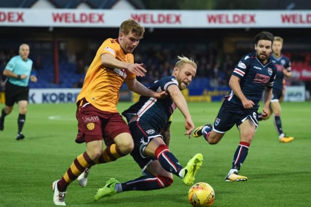 Ross County's Andrew Davies, right, tackles Motherwell's Chris Cadden. Picture: Craig Foy/SNS