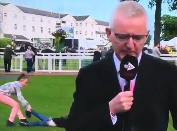 Jim Delahunt remains professional as the small boy is dragged away in the background. Picture: Contributed