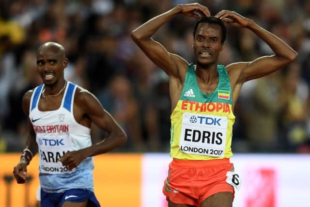 Mo Farah looks on as 5,000m winner Muktar Edris performs the formers famous Mobot celebration.
Photograph: Shaun Botterill/Getty Images