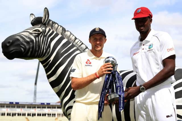England captain Joe Root, left, and West Indies counterpart Jason Holder with the series trophy and a zebra, which features on the sponsor's logo. Picture: Tim Goode/PA