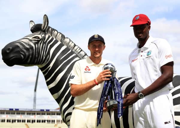 England captain Joe Root, left, and West Indies counterpart Jason Holder with the series trophy and a zebra, which features on the sponsor's logo. Picture: Tim Goode/PA