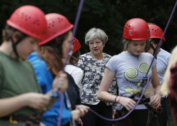 Britain's Prime Minister Theresa May talks with participants as they prepare to take part in an activity at the Woodlands Outdoor Education Centre in Glasbury, eastern Wale. Picture: ADRIAN DENNIS/AFP/Getty Images