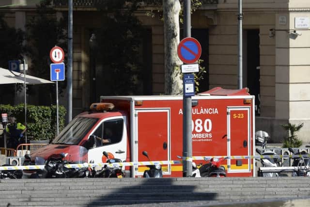 A policeman stands next to an ambulance after a van ploughed into the crowd, injuring several persons on the Rambla in Barcelona. Picture: Getty