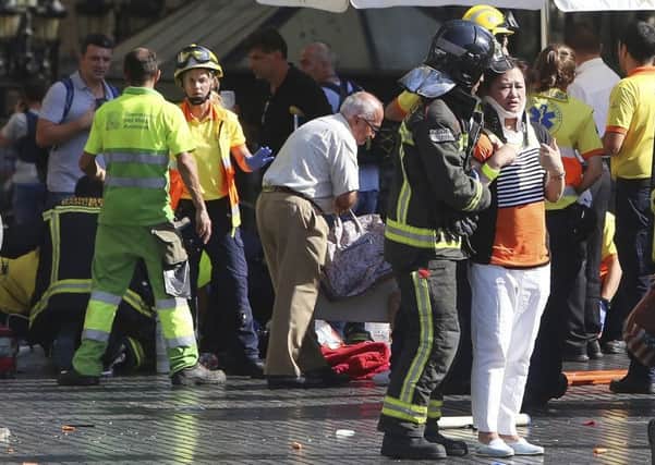 Injured people are treated in Barcelona after yesterday's attack on Las Ramblas. Picture: AP