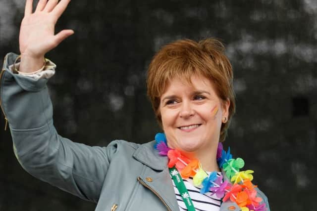 First Minister Nicola Sturgeon waves as she addresses the assembled crowd at Glasgow Pride. (Photo by Robert Perry/Getty Images)