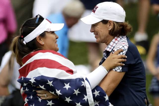 United States Lizette Salas, left, celebrates with team captain Juli Inkster after clinching the winning point. Picture: AP.