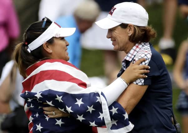 United States Lizette Salas, left, celebrates with team captain Juli Inkster after clinching the winning point. Picture: AP.