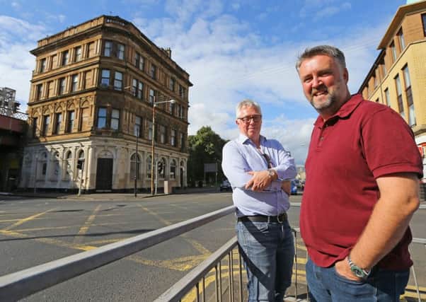 David Low(L) and Peter McGowan on Bridge Street in Glasgow. Peter bought a penthouse flat  (in background) from David using the cryptocurrency ScotCoin. Picture: SWNS