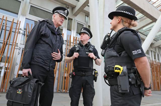Police Scotland Chief Constable Philip Gormley (left) talks to police officers with Tasers outside Scottish Parliament in Edinburgh. PRESS ASSOCIATION Photo. Picture date: Tuesday March 28, 2017. Police officers carrying Tasers will now patrol outside the Scottish Parliament. MSPs have been informed of the increased security following last week's Westminster attack. Police Scotland said the measure was an operational contingency matter and was not based on any intelligence threat in relation to Holyrood. See PA story POLICE Scotland. Photo credit should read: Andrew Milligan/PA Wire