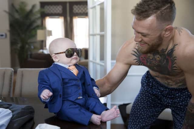 Conor McGregor with son Conor Jack dressed in a suit especially  fitted by menswear designer David August Heil at McGregors home in Las Vegas. Picture: Emily Wilson/NewYork Times.