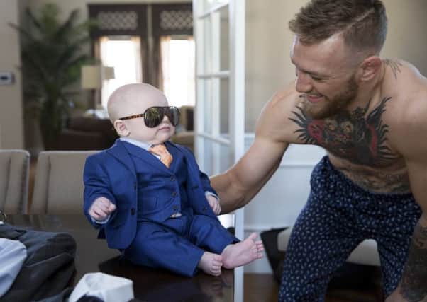 Conor McGregor with son Conor Jack dressed in a suit especially  fitted by menswear designer David August Heil at McGregors home in Las Vegas. Picture: Emily Wilson/NewYork Times.