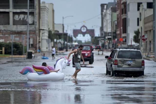 People make their way down partially flooded roads in unusual ways. Picture: BRENDAN SMIALOWSKI/AFP/Getty Images
