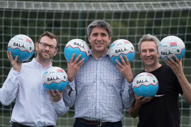 Ryan Mackie joins Hugh Aitken and Angus Coull in kicking off the Homeless World Cup with the specially designed balls. Picture: Supplied