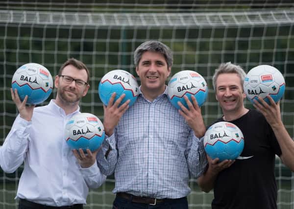 Ryan Mackie joins Hugh Aitken and Angus Coull in kicking off the Homeless World Cup with the specially designed balls. Picture: Supplied