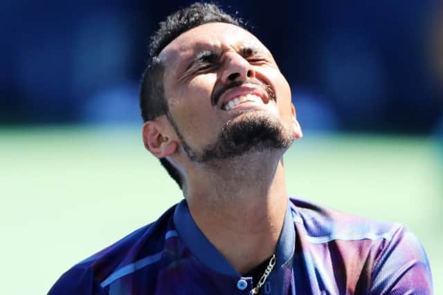 Nick Kyrgios grimaces in pain from a shoulder injury during his defeat by compatriot John Millman. Picture: Richard Heathcote/Getty Images