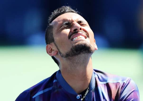 Nick Kyrgios grimaces in pain from a shoulder injury during his defeat by compatriot John Millman. Picture: Richard Heathcote/Getty Images