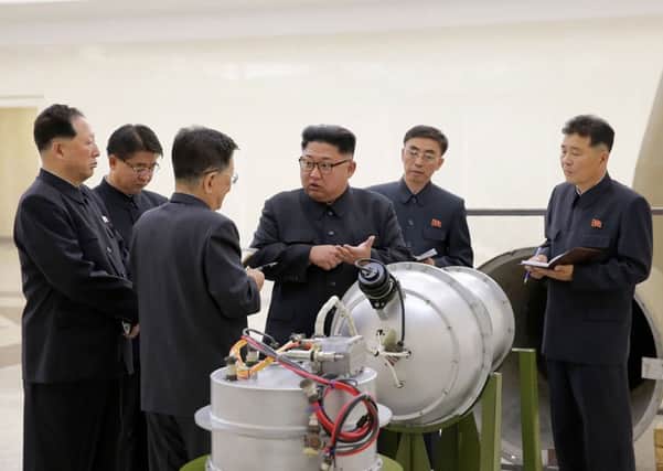 North Korean leader Kim Jong-Un (C) looking at a metal casing with two bulges at an undisclosed location. Picture: AFP/KCNA via KNSA