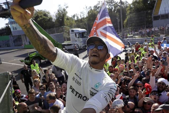 Lewis Hamilton captures the moment as he celebrates on the podium at the Italian Grand Prix. Picture: PA.