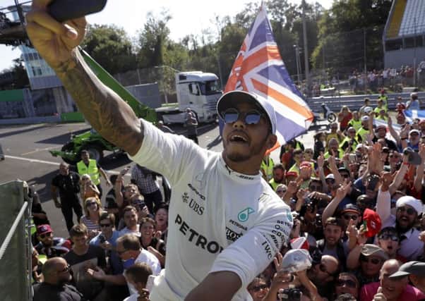Lewis Hamilton captures the moment as he celebrates on the podium at the Italian Grand Prix. Picture: PA.