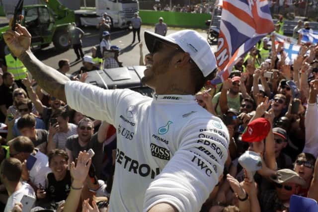 Lewis Hamilton of Britain takes a selfie with supporters after winning the Italian Formula One Grand Prix, at Monza