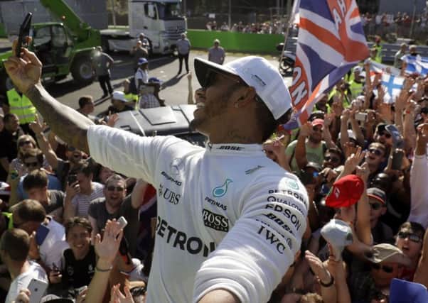Lewis Hamilton of Britain takes a selfie with supporters after winning the Italian Formula One Grand Prix, at Monza