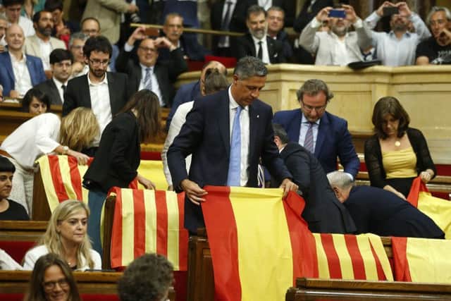 Members of the Catalan Popular Party display Spanish flags in the regional assembly before a vote on the referendum. Picture: AP