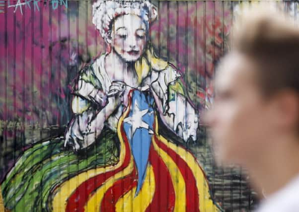 Graffiti by street artist "Zecarrion" depicting a woman sewing an Esteladas (Pro-indepence Catalan flag) in Barcelona. Picture: AFP/Getty Images