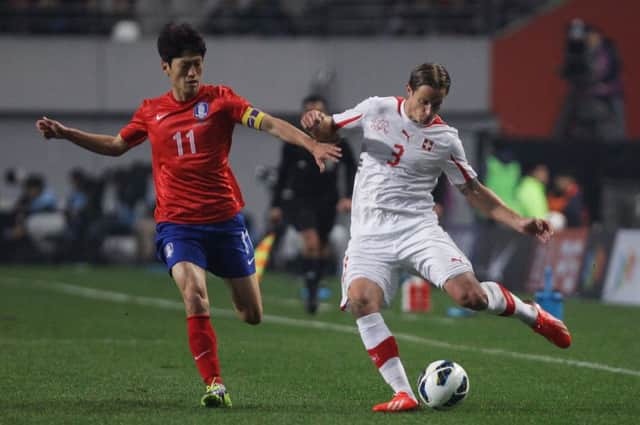 Reto Ziegler attempts to evade the attentions of Lee Chung-Yong of South Korea during a match in 2013. Picture: Getty Images